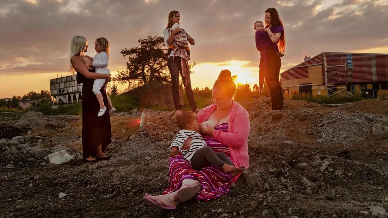 Donne che allattano i propri figli in un ambiente all’aperto al tramonto, tema della mostra The Invisible Breasts