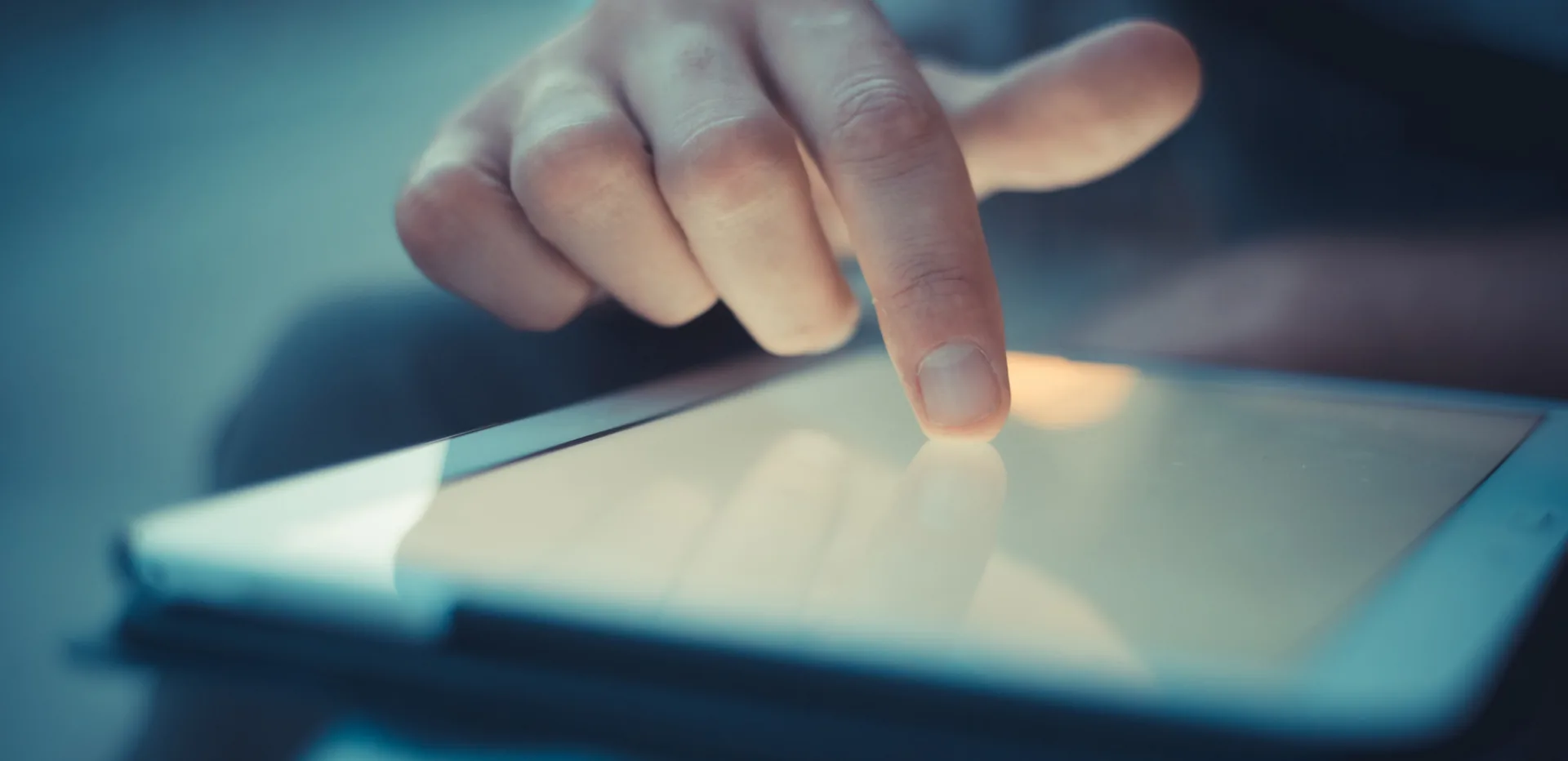 Mano che interagisce con lo schermo di un tablet per accedere a contenuti di mobile learning