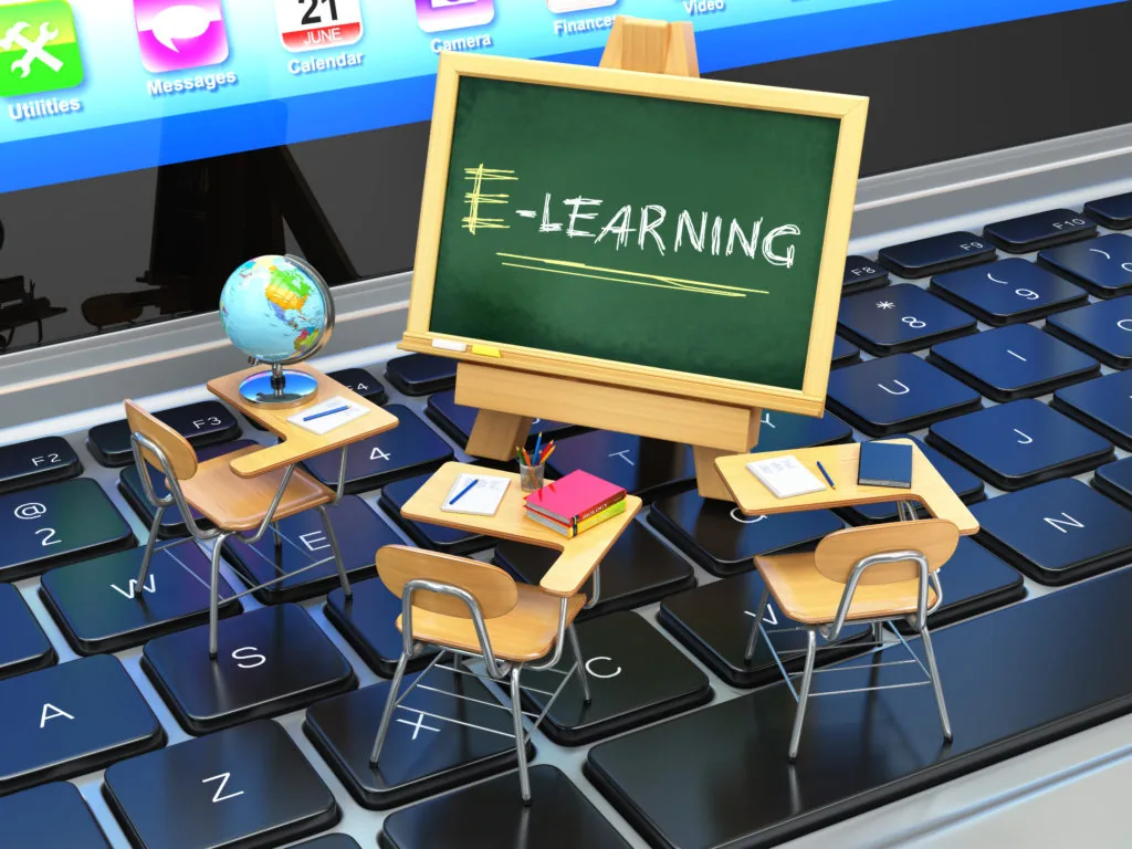 Banchi di scuola, mappamondo e lavagna con scritta e-learning su tastiera di computer