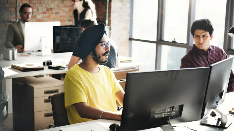 Persone che lavorano insieme in un ufficio moderno, rappresentando il coinvolgimento del management nell'eLearning aziendale