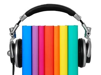 Cuffie over-ear nere posizionate sopra una fila di libri colorati, simbolo di apprendimento digitale e ascolto audio