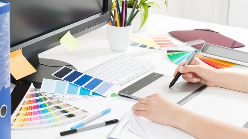Scrivania con monitor, tastiera, tavolette grafiche e palette colori per progettare elementi visivi di un corso e-learning