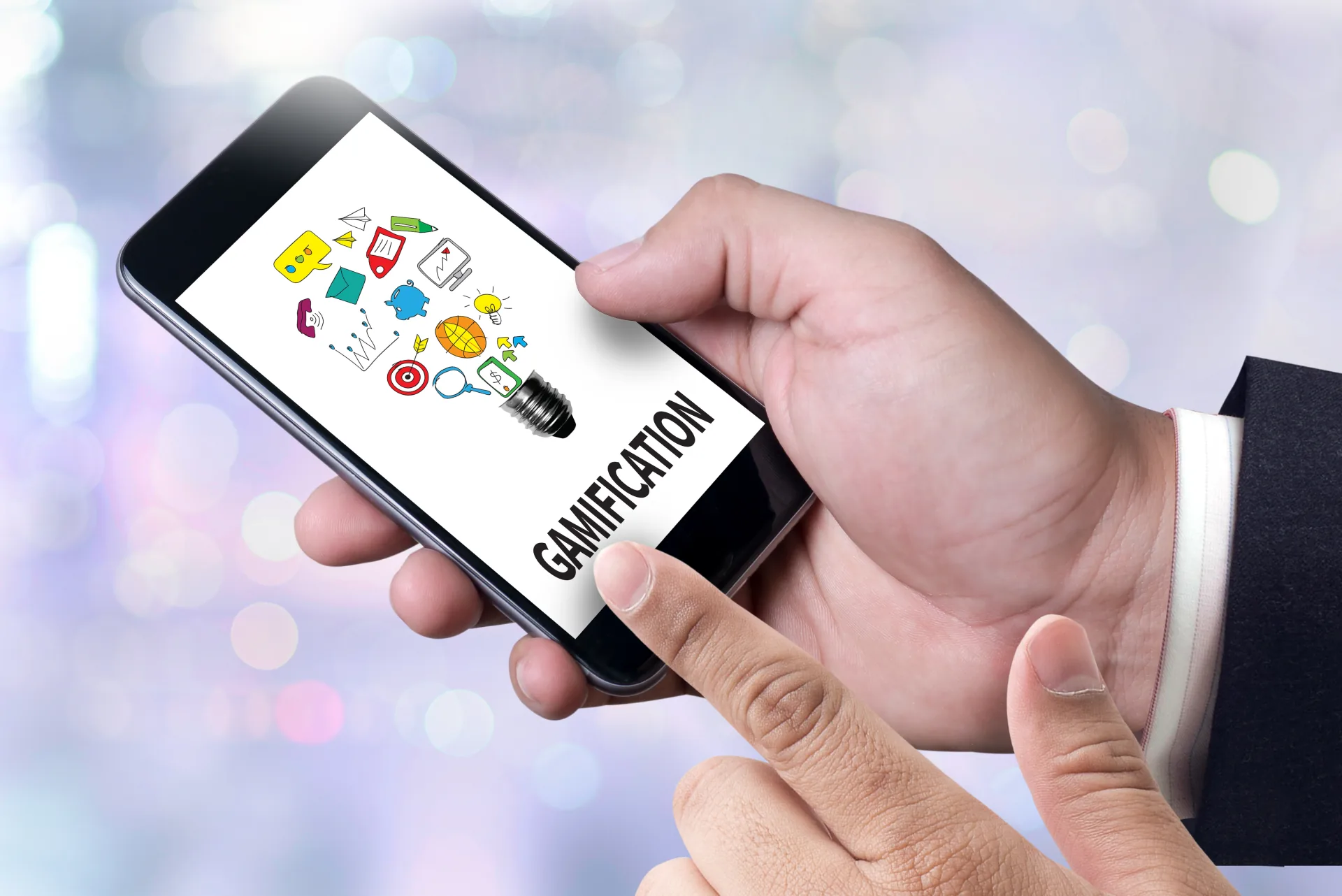 Mano che tiene uno smartphone con la scritta gamification e icone colorate che rappresentano elementi ludici e formativi