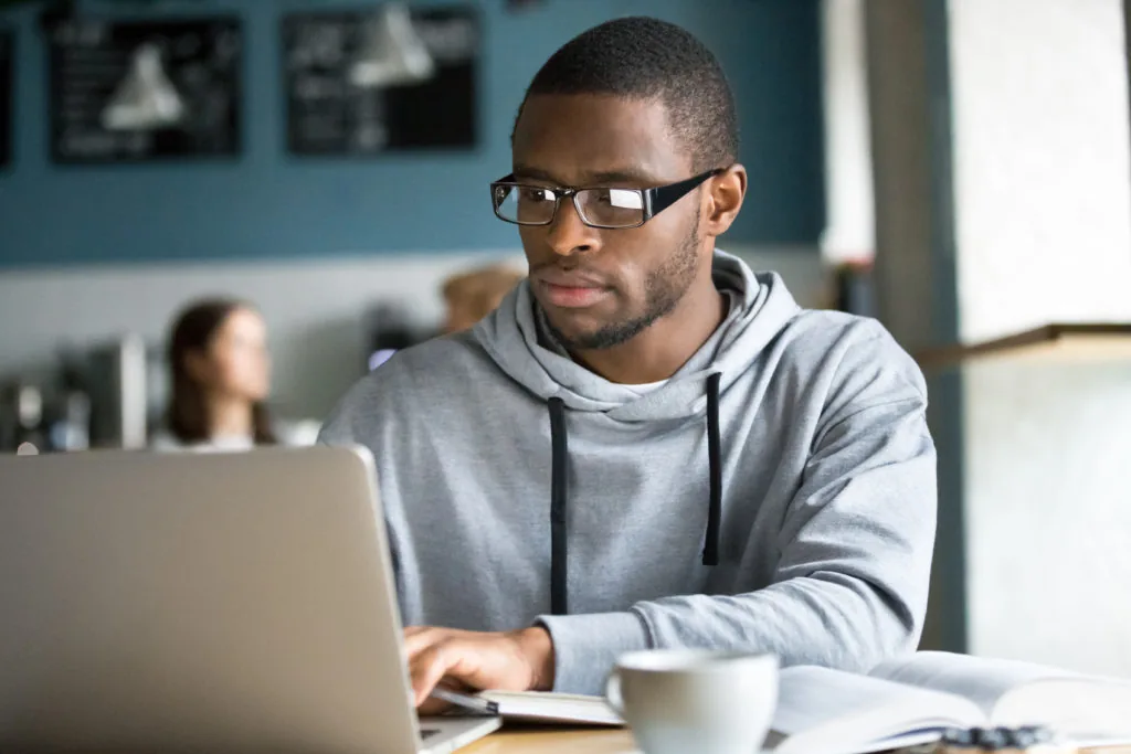 Persona al computer che lavora su file digitali, rappresentando la gestione dei file sorgente nei corsi e-learning