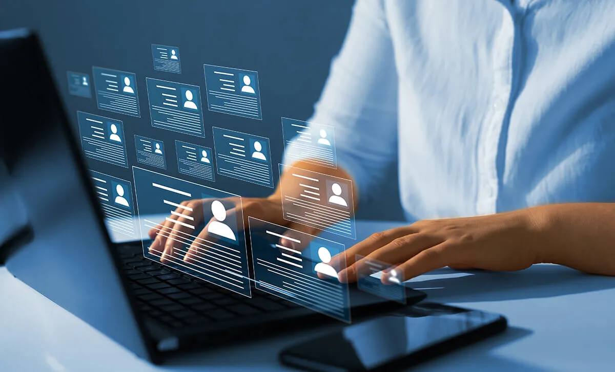 Persona al computer con profili digitali di dipendenti, simbolo della gestione HR nella formazione aziendale