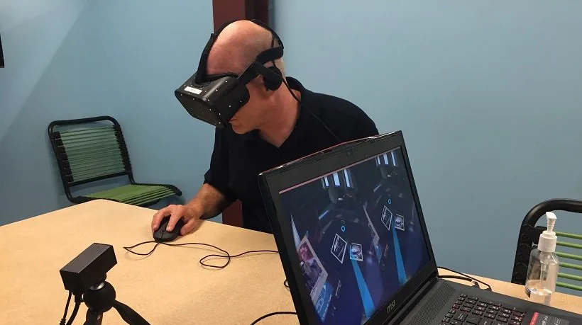 Persona con visore VR utilizza un computer per simulazione immersiva in un contesto di apprendimento digitale