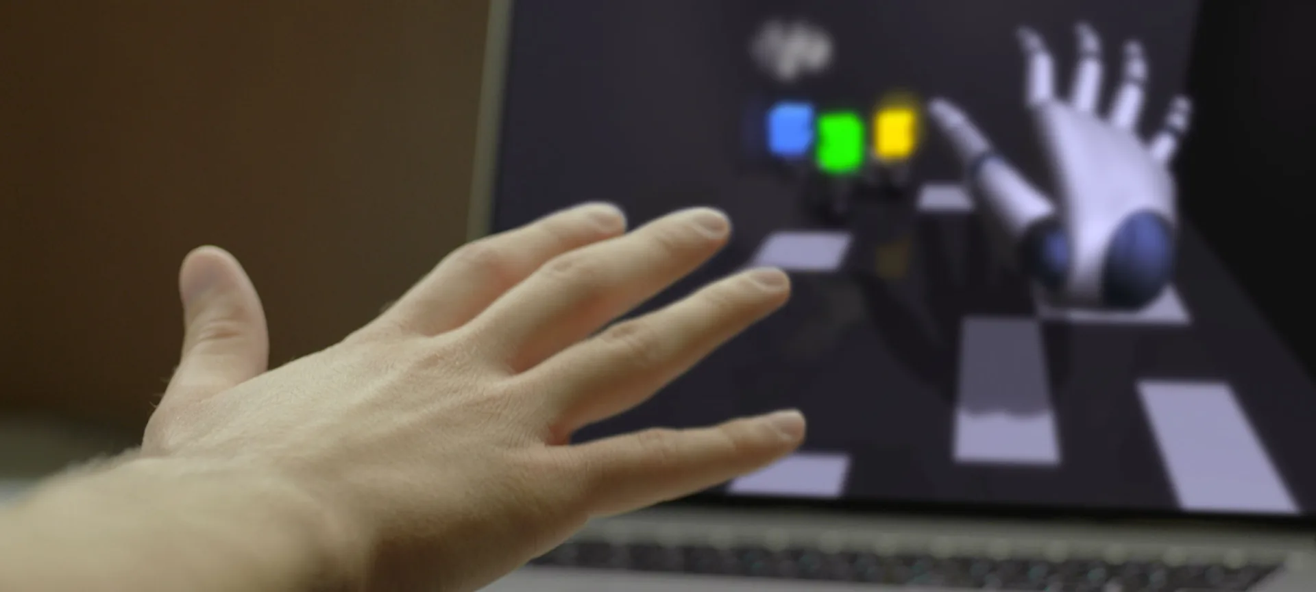 Mano umana che interagisce con un ambiente digitale 3D tramite Leap Motion su schermo