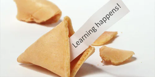 Biscotto della fortuna spezzato con il messaggio Learning happens che richiama il tema dell’apprendimento continuo