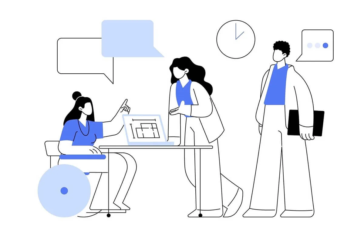 Tre persone diverse, inclusa una su sedia a rotelle, collaborano attorno a un tavolo con computer e fumetti di dialogo