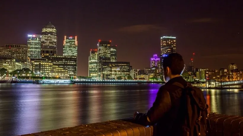 Persona osserva lo skyline di una città moderna illuminata di notte, simbolo di innovazione e futuro nel corporate learning