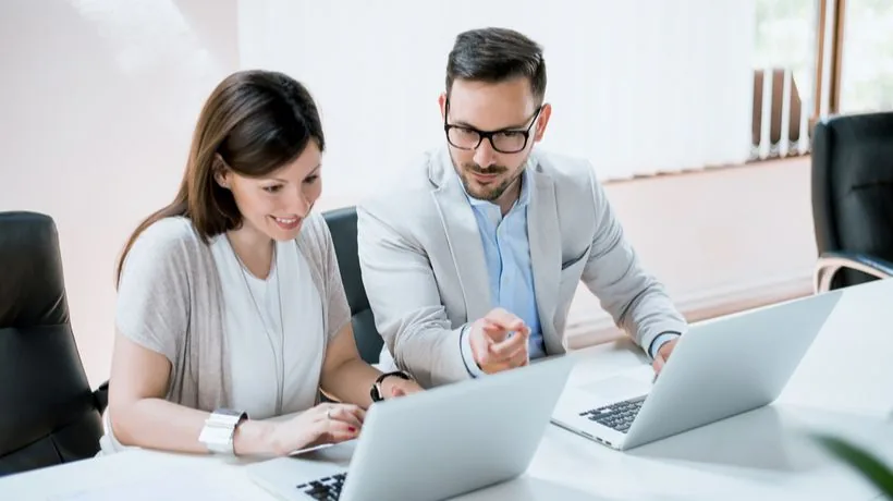 Due colleghi collaborano davanti ai laptop per analizzare le performance della formazione elearning in ufficio