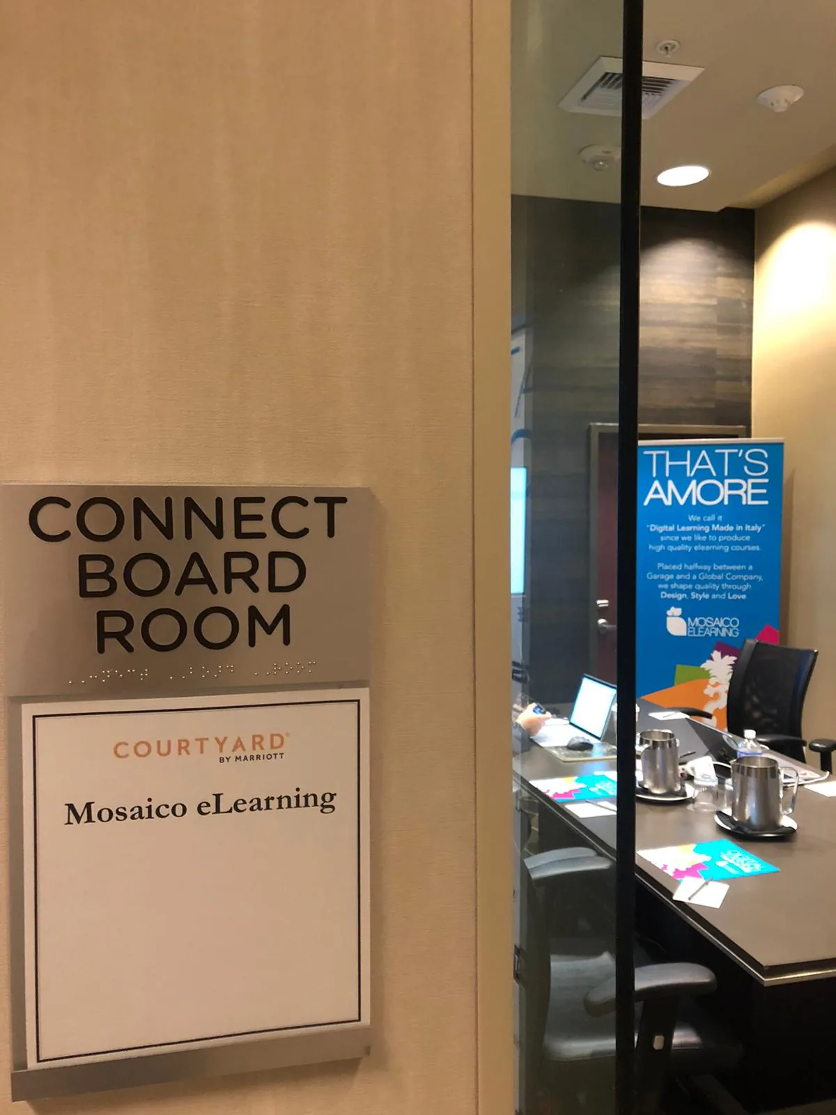 Sala riunioni Connect Board Room con cartello Mosaico eLearning e materiale promozionale per Digital Learning Made in Italy