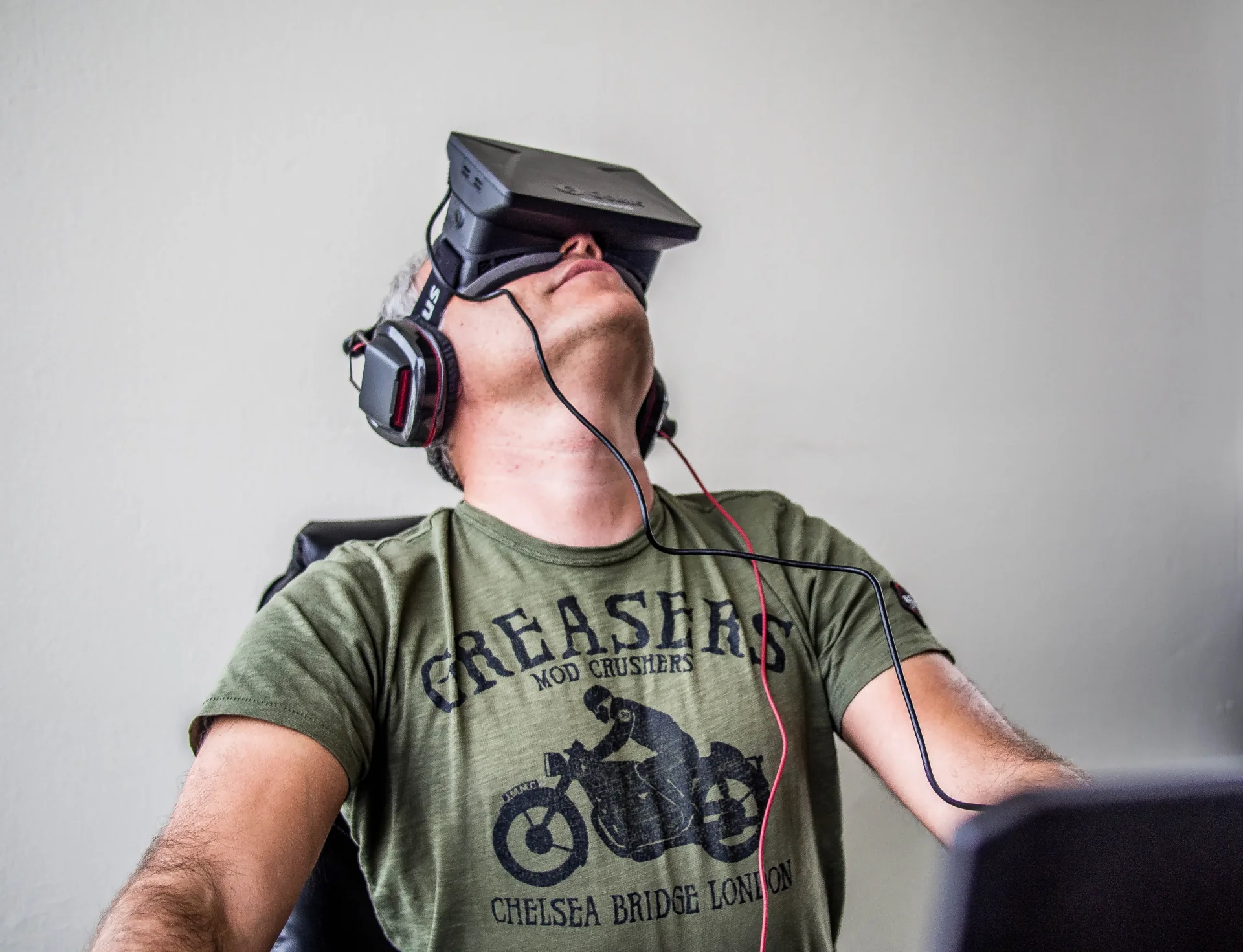 Persona seduta con visore Oculus Rift e cuffie, immersa in un’esperienza di realtà virtuale per l’apprendimento digitale