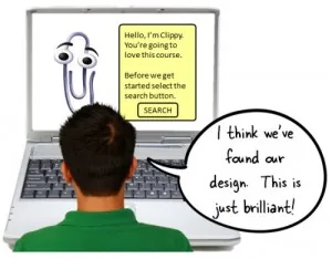 Un uomo osserva un prototipo di corso elearning su laptop con Clippy di PowerPoint e un messaggio di approvazione