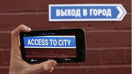 Uno smartphone inquadra un cartello in russo e mostra la traduzione inglese tramite realtà aumentata