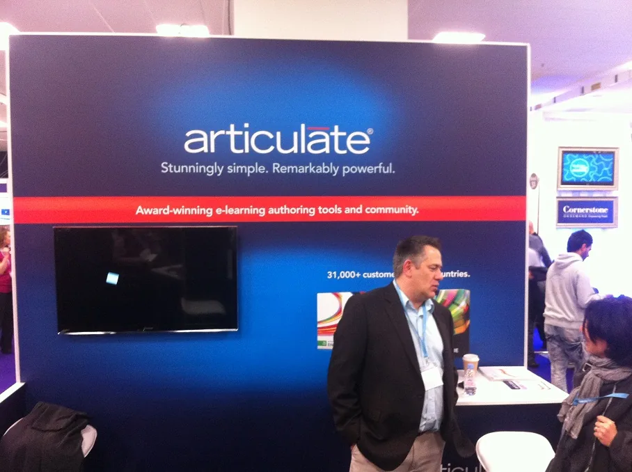 Stand Articulate con schermo spento e due persone che dialogano durante Learning Technologies 2013 a Londra