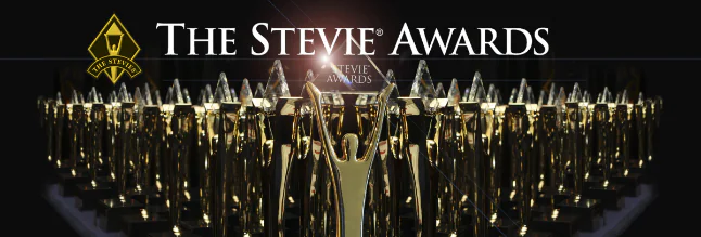 Premi Stevie Award dorati allineati con logo e scritta The Stevie Awards su sfondo nero