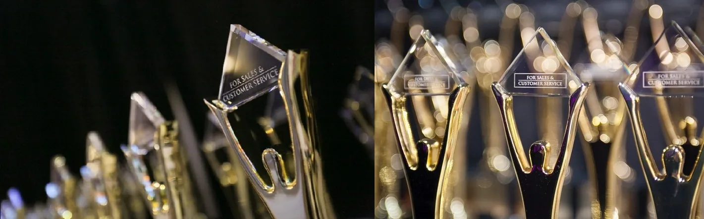 Trofei dorati Stevie Award con base trasparente, simbolo del riconoscimento agli International Business Awards