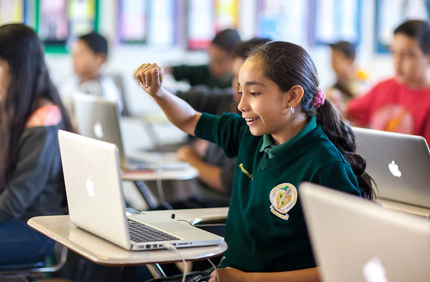 Studentessa interagisce con un laptop usando gesti della mano in aula durante una lezione digitale