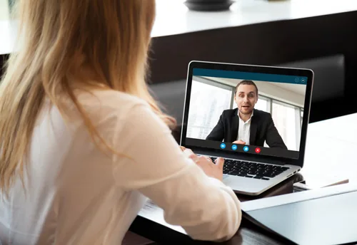 Donna segue una videochiamata su laptop con un uomo in abito, simbolo di social learning e formazione digitale