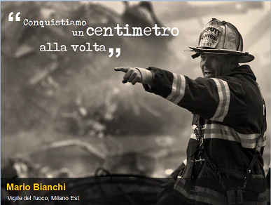 Vigile del fuoco in divisa indica una direzione durante un intervento, con citazione motivazionale in sovrimpressione